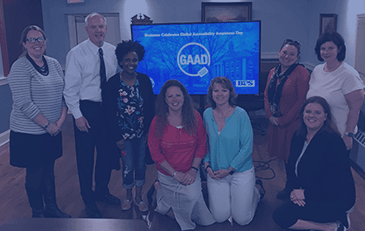 Town representatives pose for a group photo in front of GAAD logo