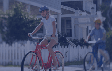 Image of girl riding on a bike in suburban neighborhood